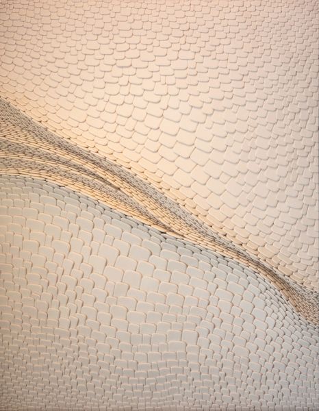 Soft, textured ivory fabric with a curved seam or stitching line running diagonally across; resembles snakeskin pattern on a garment.