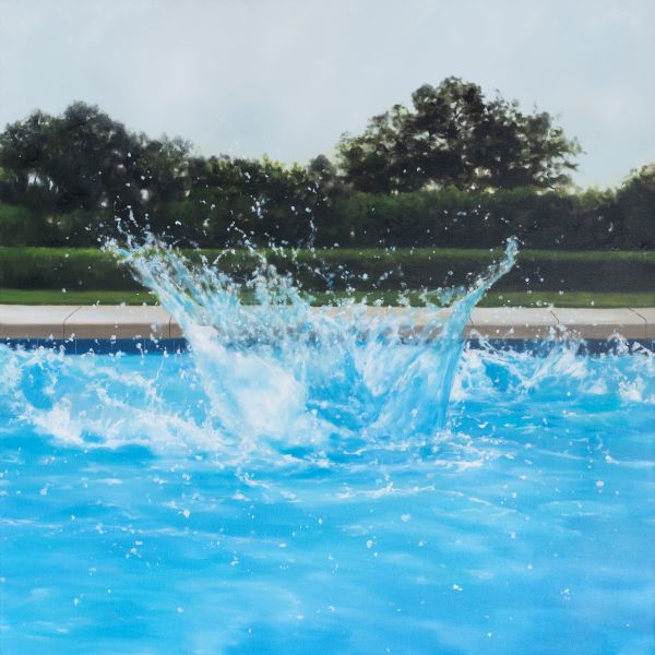 A splash erupts from a bright blue pool, water droplets flinging into the air against a green, tree-lined backdrop.