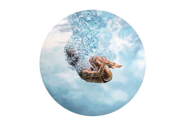 Two kids splashing into a pool, mid-dive, water bursting upward in a circular framing.